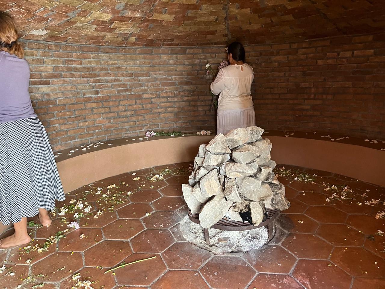 Interior del espacio de temazcal con flores y piedras